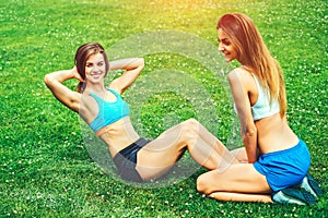 Two cute sporty girls workout together outdoor