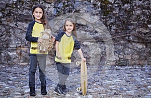 Two cute teenage females with skateboard and plushy toy. photo