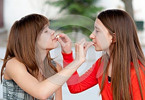 Two cute teenage girls feeding each other