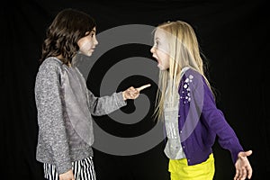 Two cute young girls arguing one girl pointing finger