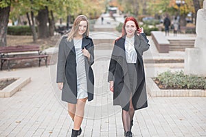 Two cute young girls are walking and talking about important topics.