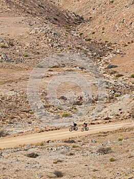 Two cyclists go for an off-road ride on a mountain path in Oman