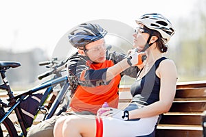 Two cyclists putting on helmet