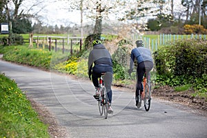 Two cyclists riding together on an english countryside road