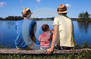 Two dads and a kid at a river photo