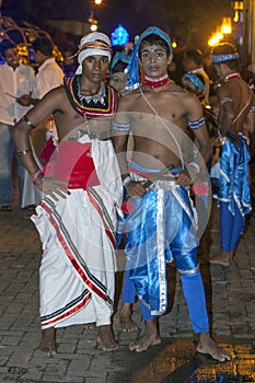 Two dancers dressed in traditional Sri Lankan costumes wait for the commencement of the Esala Perahera in Kandy, Sri Lanka.