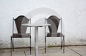 Two dark chairs against white wall welcoming guests