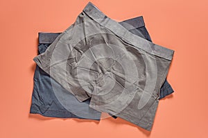 Two dark new male underpants, boxers on orange background. Top view