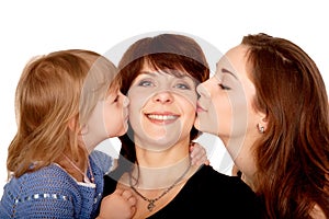 Two daughters kissing mother. Motherhood concept.