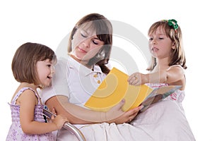 Two daughters listening mother reading book
