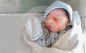 Two days old newborn baby boy, sleeping in hospital cot