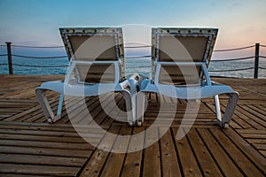 Two deck chairs at pier