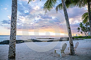 Two deck chairs at sunset on an empty beach at Lefaga, Matautu,