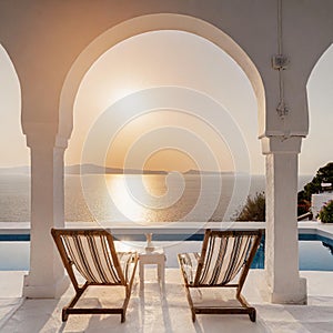 Two deck chairs on terrace with pool with stunning sea view. Traditional mediterranean white architecture with arch. Summer