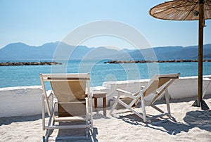 Two Deckchairs Under Parasol