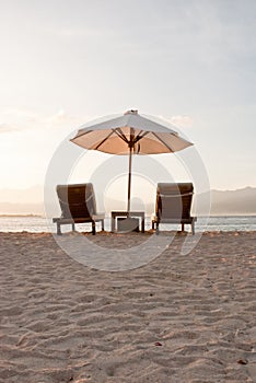 Two deckchairs on a white sandy beach