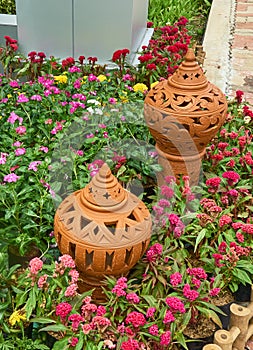 Two decorated clay pots in the flowers garden.