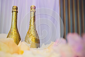 Two decorative gold bottles of luxury champagne with copyspace for your New Year, Christmas or wedding greeting or