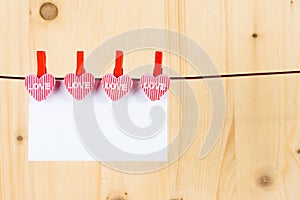 Two decorative hearts with greeting card hanging on wood background, concept of valentine day in love