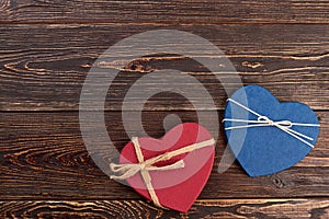 Two decorative hearts on wooden background.