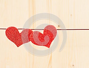 Two decorative red hearts hanging on wood background, concept of valentine day