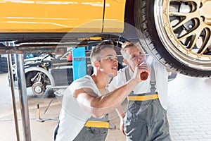 Two dedicated auto mechanics tuning a car through the modificati photo