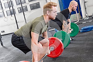 Two dedicated men trains deadlift at fitness gym center