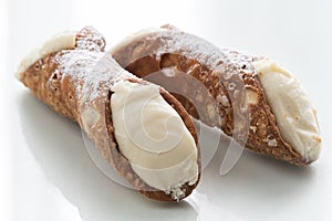 Two delicious cannoli on white background, typical Sicilian pastry