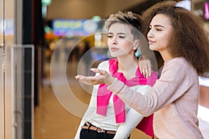 Young woman showing something in the shop window to her husband