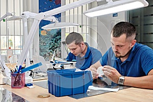 Two dental technicians working in a dental laboratory. Dental implant manufacturing process