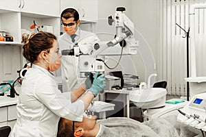 Two dentists treat a patient. Professional uniform and equipment of a dentist. Healthcare Equipping a doctors workplace