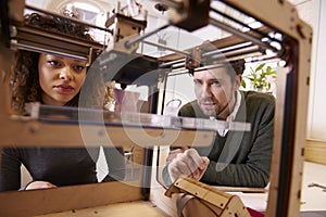 Two Designers Working With 3D Printer In Design Studio photo