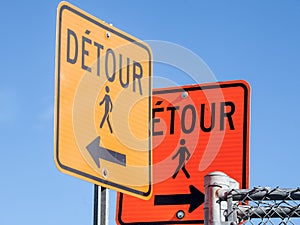 Two Detour road signs, orange color, complying with North American rules indicating a deviation for pedestrians