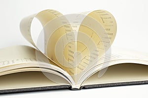 Two diary pages with dates that becomes one heart shape. Clean front view photo of diary on white background, as concept for