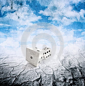 Two dice in motion, droughts desert , cloudy sky