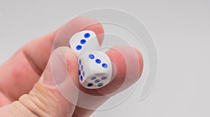 Two dice with numbers three in hand.