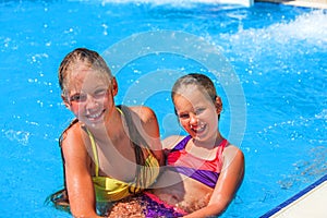 Two different ages children swim in swimming pool.