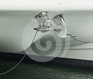 Two different anchors, plow type and another spade type mounted on the bow of modern sailing catamaran