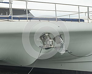 Two different anchors, plow type and another spade type mounted on the bow of modern sailing catamaran
