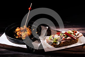 Two different and clasical Spanish tapas on a rustic table with a dark background. traditional spanish cuisine photo