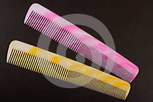 Two different colored hairbrushes on a dark background