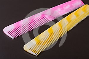 Two different colored hairbrushes on a dark background