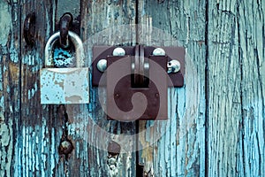 Two different locks on very old wooden garage door, peeling pain