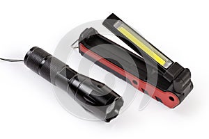 Two different modern electric LED flashlights on a white background