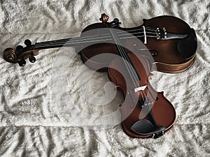 Two different size of violins put on soft cotton cloth