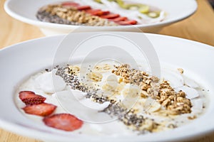 Two different Smoothie bowl with a selection of fruit granola, chia seed and coconut yogurt