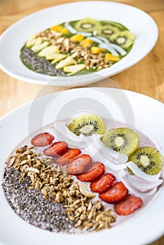 Two different Smoothie bowl with a selection of fruit granola, chia seed and coconut yogurt