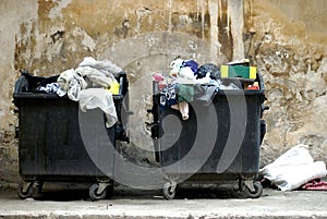 Two dirty garbage containers fool of trash