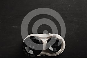 Two disposable paper cups of coffee and a disposable cup holder on a black wooden background.