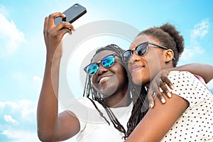 Two diverse african girls taking self portrait with phone. photo